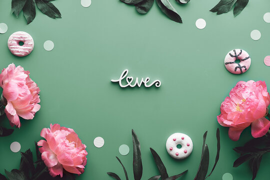 Peony greeting card, word love on mint green background. Pink peony flowers, leaves and sweet donuts, doughnuts. Mother's day, birthday, romantic greeting card flat lay design.