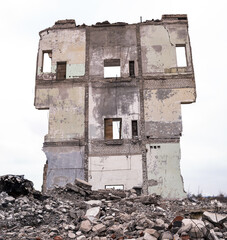 Panorama of the picturesque gloomy wall of the remains of a destroyed house against the gray sky....
