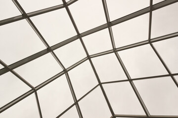 Obraz premium view from bottom to top of glass and still pyramid dome with cloudy sky