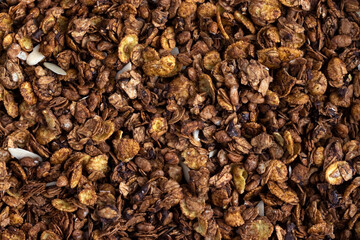 Organic homemade roasted granola cereal with oats, flax, almonds, chocolate and sunflower seeds. Top view muesli background texture