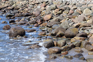 Fototapeta premium Waves Lapping Smooth Stones of Sunny Beach 