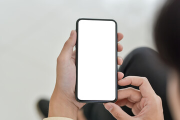 Close up of a man hand hold a smartphone blank white screen in the office.