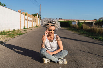 Fototapeta na wymiar Linda mujer española de pelo rizado con tatuajes en la calle