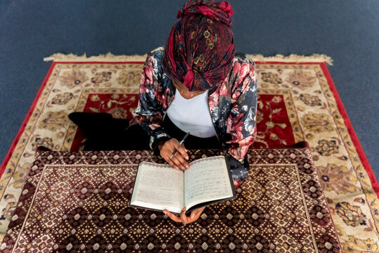 Black Muslim Woman studying in blue room