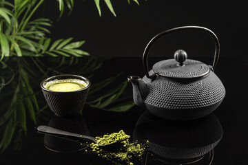 Matcha tea powder and tea accessories on black background. Tea ceremony. Traditional japanese drink.