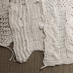 close up of knitted cotton fibre fabric swatches on a tan-coloured synthetic material