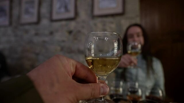 man and woman are tasting wine in winery, clicking glasses, wine-tasting on excursion