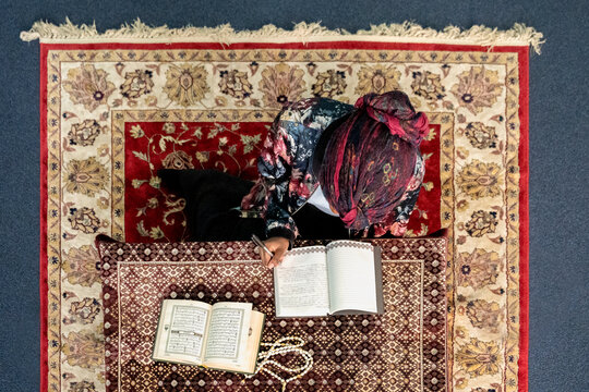 Black Muslim woman studying and reading