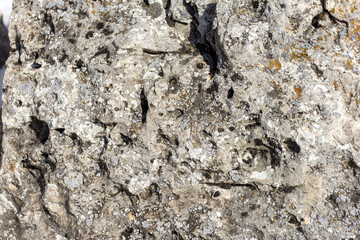 Natural mountain stone in a natural environment, rough surface burnt out in the sun and exposed to natural destruction.