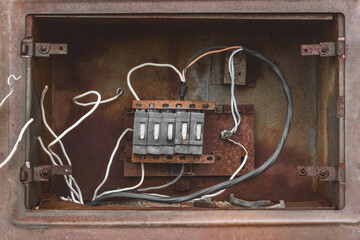 Niche of an old broken abandoned electrical industrial panel with wires, close up