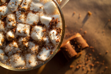 a cup of hot drink, with marshmallows, chocolate and cinnamon. 