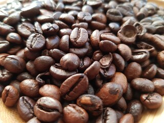 Brown coffee beans lie on a plate