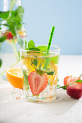 Summer detox beverage concept. Citrus fruit drinks with ice. Healthy diet cocktail with fresh berries and mint