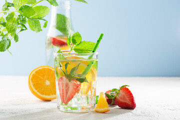 Summer detox beverage concept. Citrus fruit drinks with ice. Healthy diet cocktail with fresh berries and mint