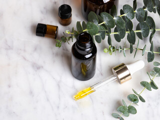 Brown glass bottle of essence or oil with natural eucalyptus leaves