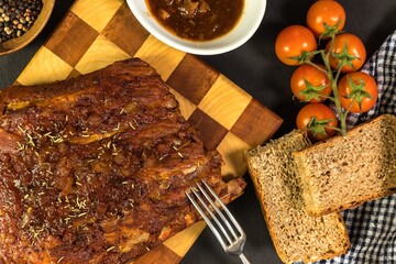 Grilled Pork ribs with honea and chili. Roasted meat on the kitchen board. Preparation of marinade from honey and chili peppers. Summer barbecue.