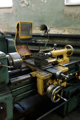 Front view of an old metal lathe in a lathe shop. The lathe components and the spindle.