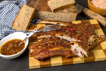 Grilled Pork ribs with honea and chili. Roasted meat on the kitchen board. Preparation of marinade from honey and chili peppers. Summer barbecue.