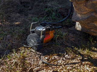 Electric compressor with gauge on ground next to tractor wheel