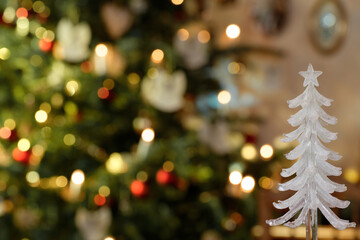 Gläsernes Weihnachtsbaumobjekt, Nahaufnahme  vor erleuchtetem Weihnachtsbaum