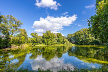 Großer Teich mit blauem Himmel und weißen Wolken im Sommer