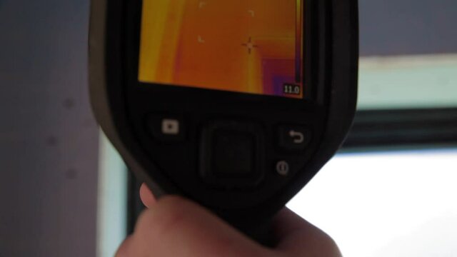 Close up shooting of a thermal imaging camera scanning the fixtures of an eco friendly house in construction insulated with hemp wool.