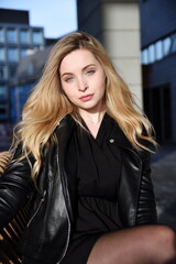 Young woman in Wroclaw city. Female student with blonde hairs, wearing black jacket.