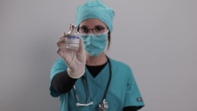 Young female doctor presents The Covid-19 vaccine - studio photography