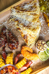 Food set of fried chicken wings, burger, fried potatoes, cheese, corn, sauce, salad