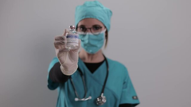 Young female doctor presents The Covid-19 vaccine - studio photography
