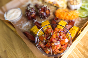 Food set of fried chicken wings, burger, fried potatoes, cheese, corn, sauce, salad