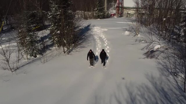 Adventurous video taken by a drone camera, featuring two young explorers making documentary of telecommunication signal towers, surrounded by snow