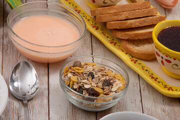 Yogurt with cereal, toast and jam on the farm's rustic table