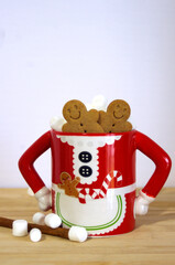 funny Mrs. Santa Clause coffee mug with hot chocolate, marshmallows, gingerbread cookies, cinnamon stick on wooden table with copy space