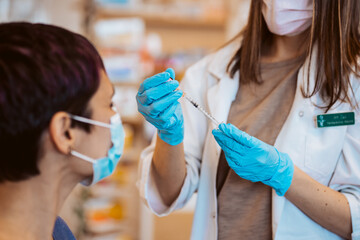 Young woman receiving the vaccine for the virus caused by covid 19. Immunization of the population....