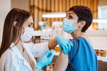 Young woman receiving the vaccine for the virus caused by covid 19. Immunization of the population....