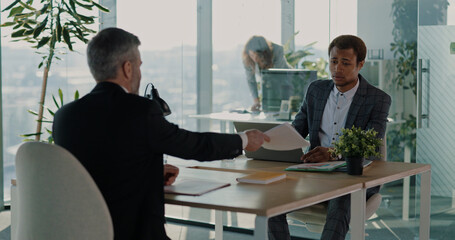 Multi-ethnic male female couple of HR managers discussing future collaboration agreement with adult businessman employee hiring for job. Office meeting.