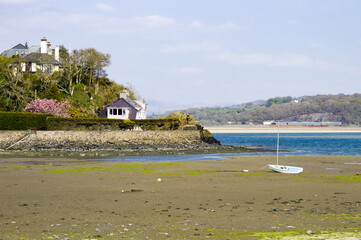 Porthmadog Wales. Pretty bay of Borth Y Gest. Boats on sand flats at low tide with view over the sea to the distant mountains of Snowdonia.