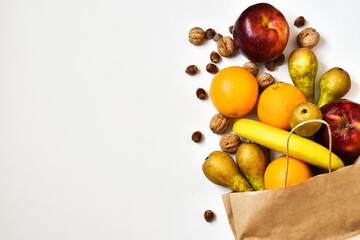 Healthy food in a paper bag of fruits on white background. Healthy food concept background. Food supermarket and clean vegan eating concept. Shopping or delivery. Flat lay. copy space. 