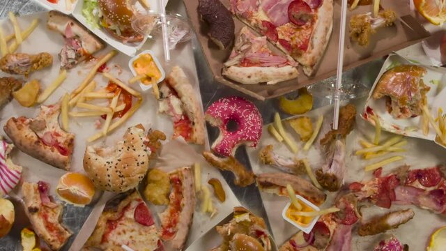 Irrational Attitude to Food. HD Loop. A wide variety of uneaten food items slowly rotate in front of the camera, symbolizing waste, irrationality and recycling