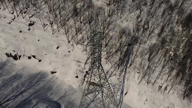 A short video from a documentary about 3G, 4G, and 5G telecommunication tower, located in a snowy area, taken from a drone camera.