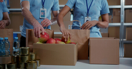 Community work. Multi-ethnic volunteer team of multi-ethnic people preparing and collecting food...