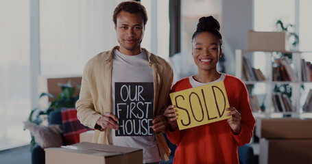 Couple of Cheerful African Family Man with Woman Fighting with Carton Posters Successful Sold Their House Moving to New Apartment Smiling Together.