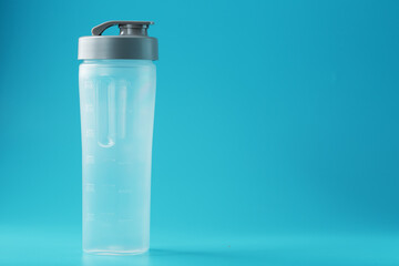 Shaker is an empty plastic smoothie cup on a blue background.