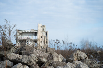 Large stone fragments of concrete close-up on the background of the remains of a destroyed...