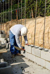 Mason setting a concrete block wall