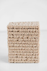 Stacked buckwheat crisp bread on a white wooden background. Copy, empty space for text