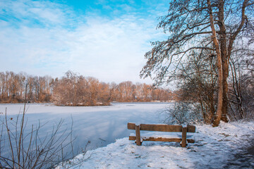 Winter landscape in Braunschweig, Lower Saxony, Germany. Snow covered Westpark and frozen lake on a...