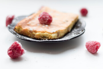 Appetizing curd casserole. Nearby is a drink and raspberries with raisins.