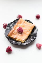Appetizing curd casserole. Nearby is a drink and raspberries with raisins.